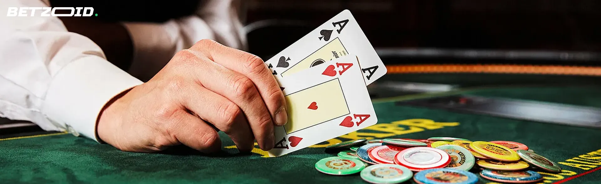 The player holds cards next to casino chips.