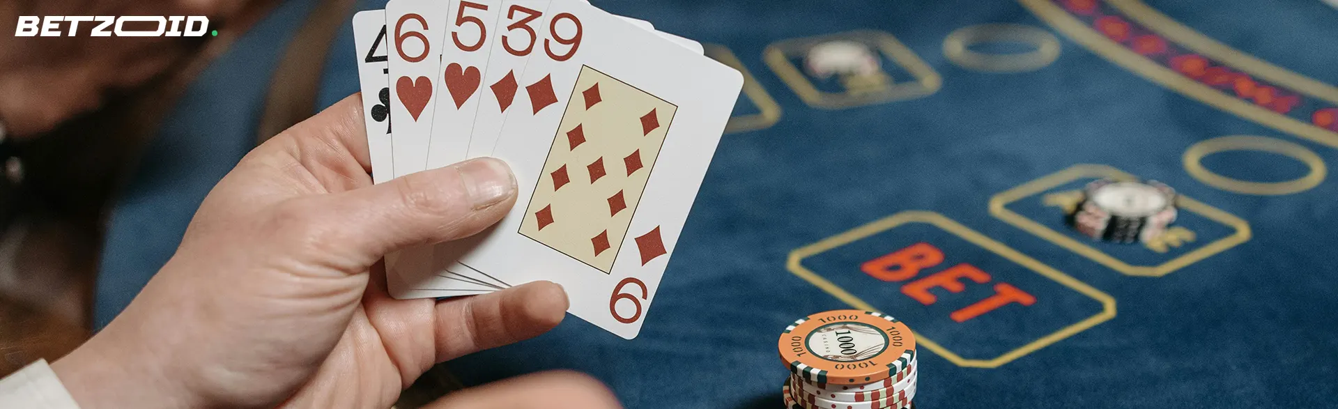 Spieler hält Karten auf dem Hintergrund des Casinotisches.