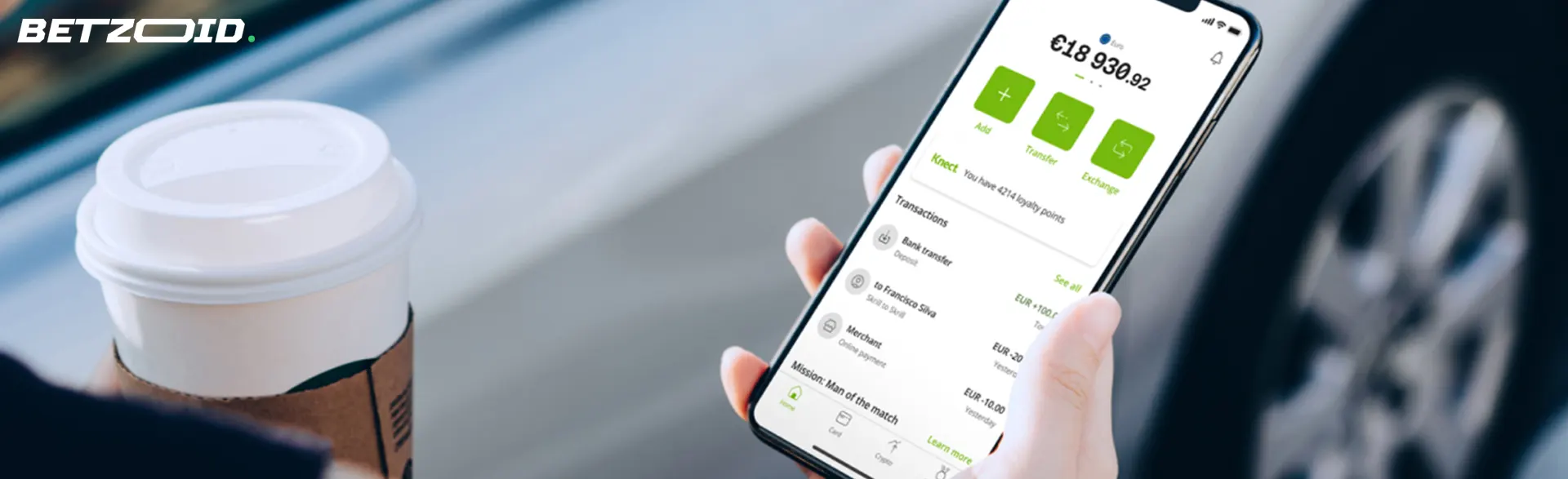 Una persona sostiene un teléfono inteligente con saldo de Neteller.