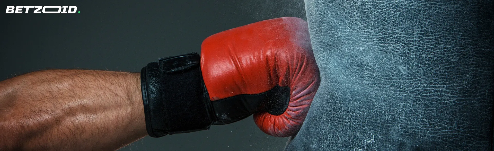 Un boxeador golpea un saco de boxeo.