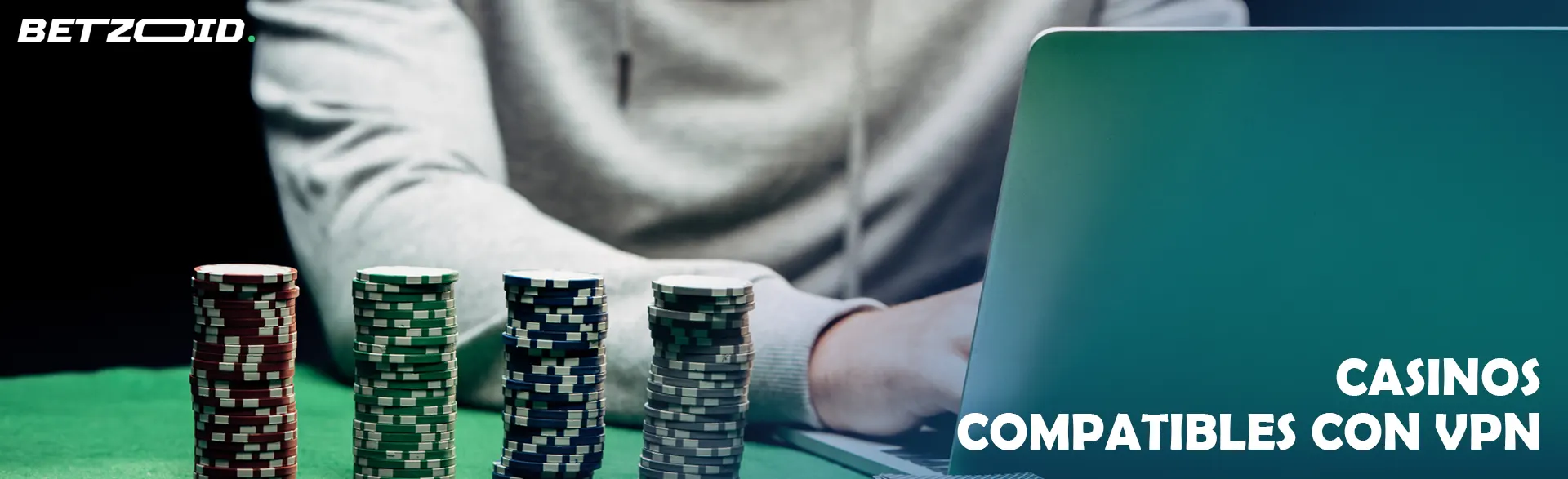 Un jugador se sienta frente a una computadora portátil al lado de fichas de casino.