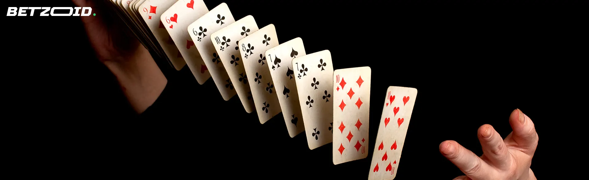 Un hombre baraja cartas sobre un fondo oscuro.