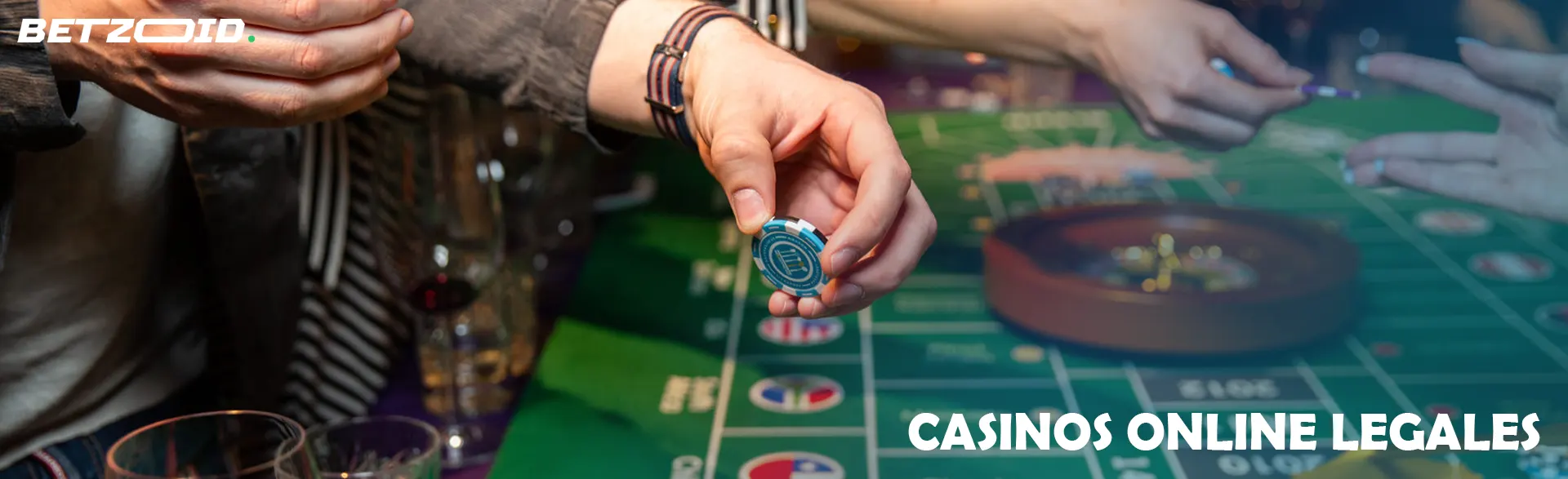 Un jugador sostiene fichas junto a una mesa de ruleta.