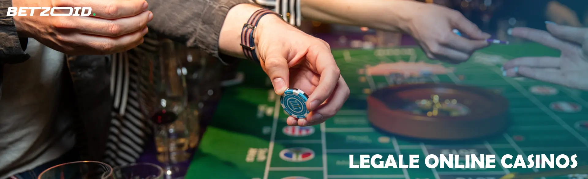 Ein Spieler hält Chips über einem Roulettetisch.