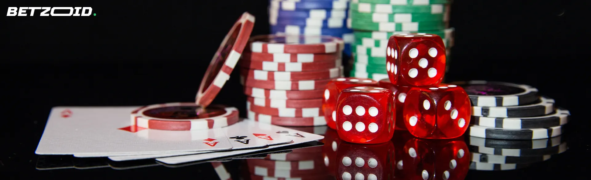 Cartas, dados y fichas de casino sobre un fondo oscuro.