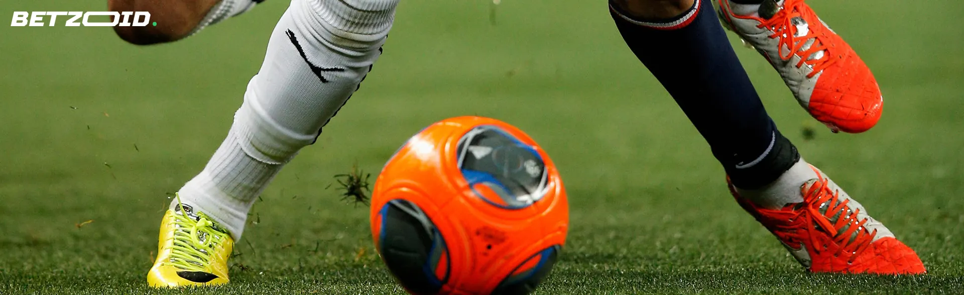 Voetballers vechten tijdens een wedstrijd om de bal.