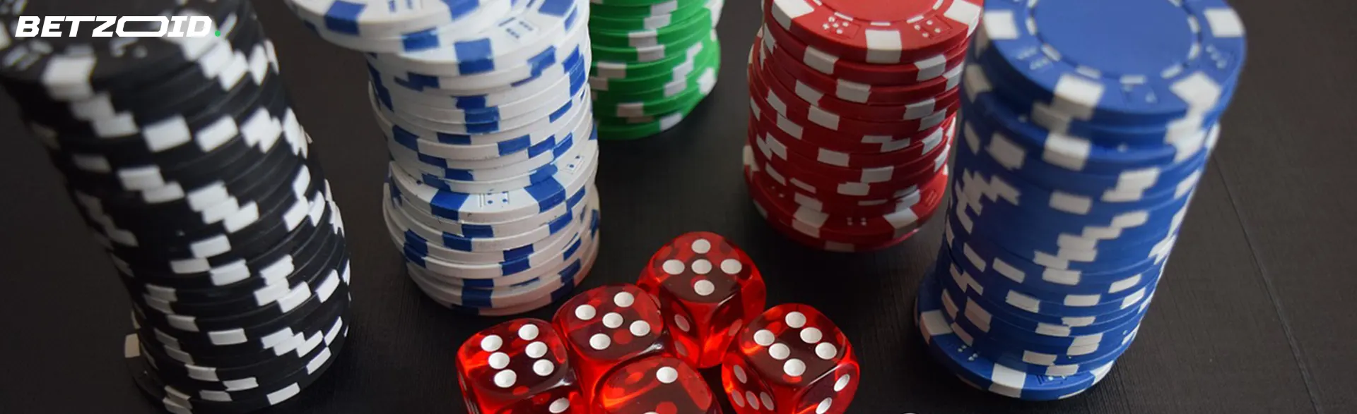 Stapel von Casino-Chips neben Würfeln.