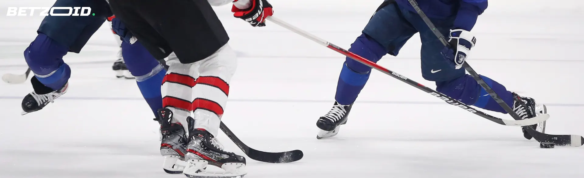 Hockeyspelare slåss om pucken på isen.