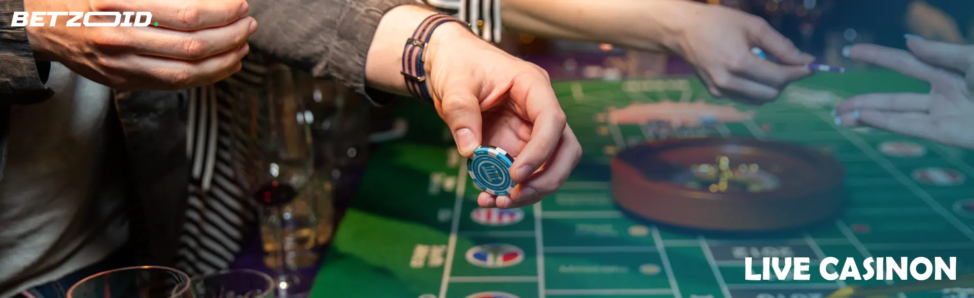 En spelare håller marker ovanför ett roulettebord.