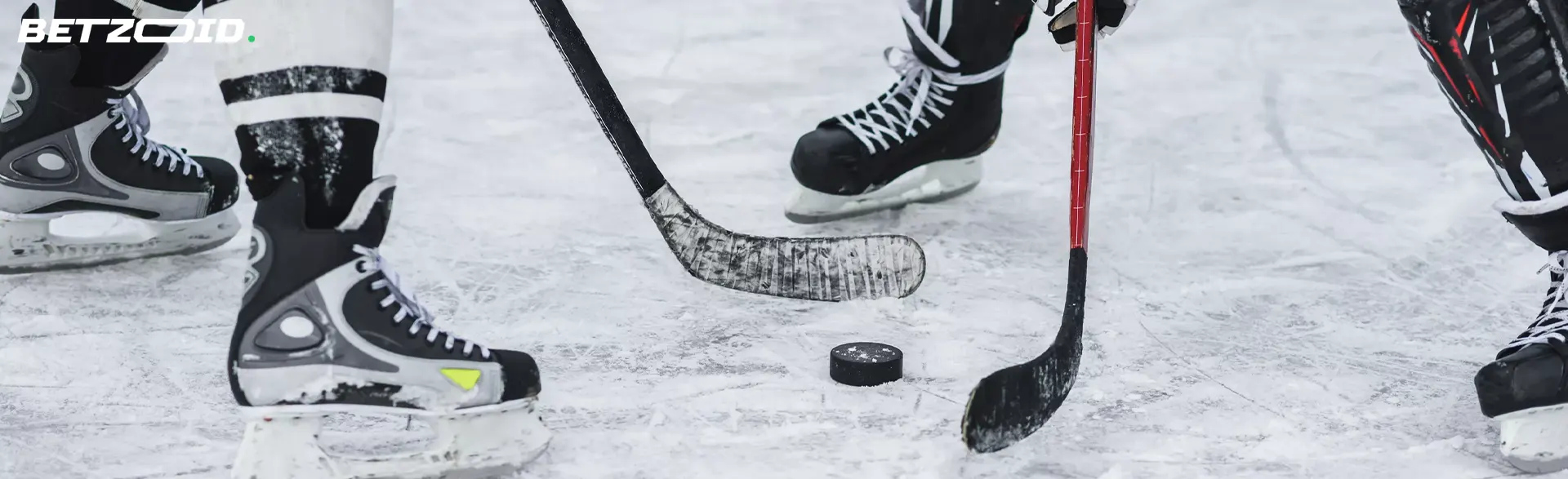 Hockeyspillere kjemper om pucken pÄ isen.