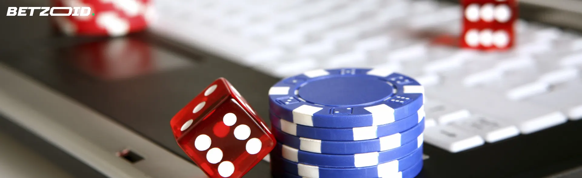 Casino-Chips und WĂŒrfel auf der Tastatur.