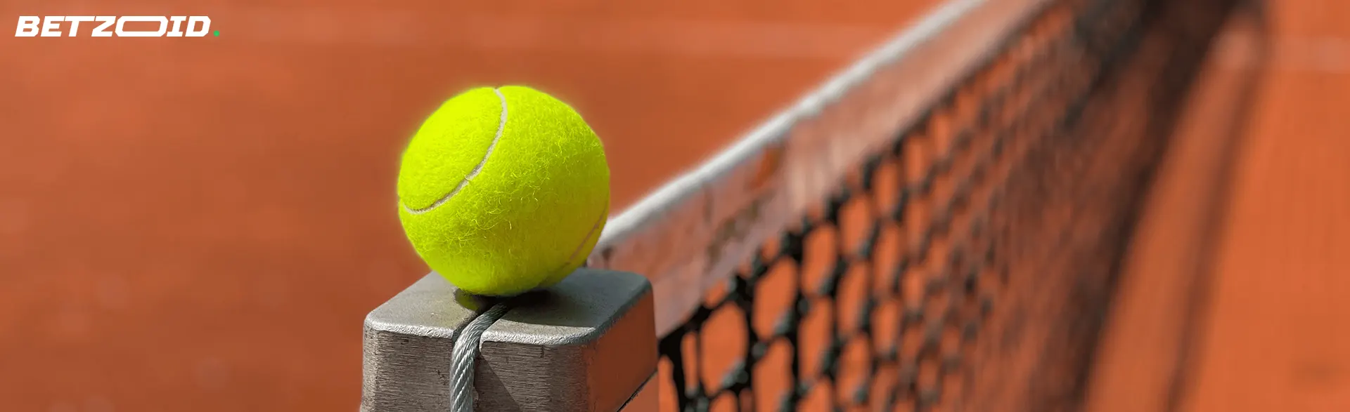 Tennisbollen ligger på kanten av nätet.