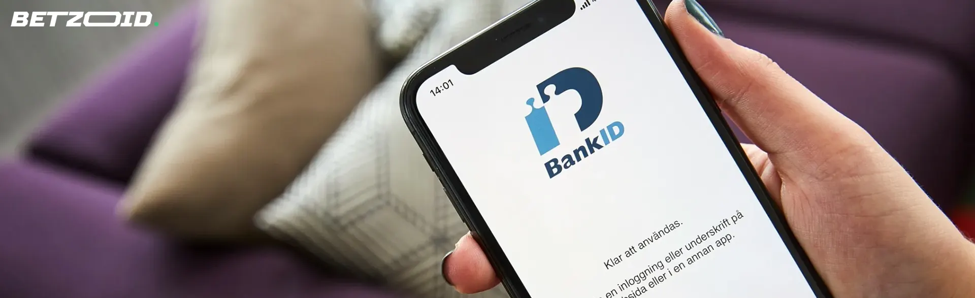 En person håller en smartphone med BankID-appen öppen.