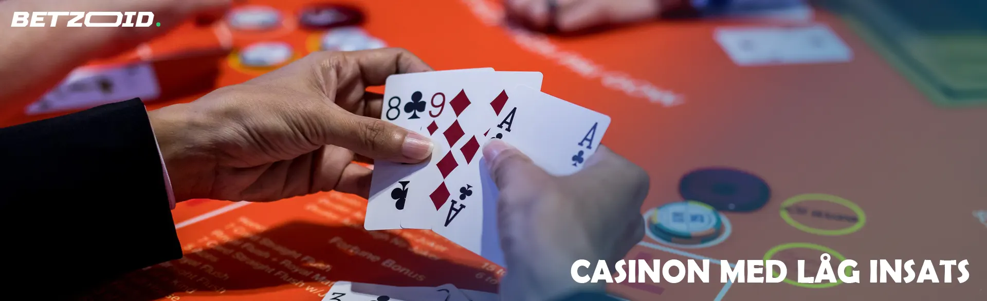 Kort i spelarens hand mot bakgrund av ett kasinobord.