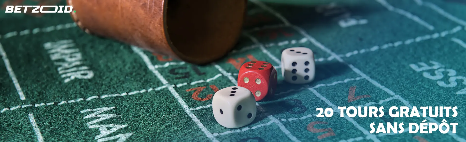 Des dés à côté d’un gobelet à lancer.