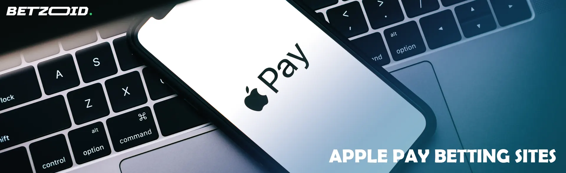 Smartphone with Apple Pay logo on laptop.