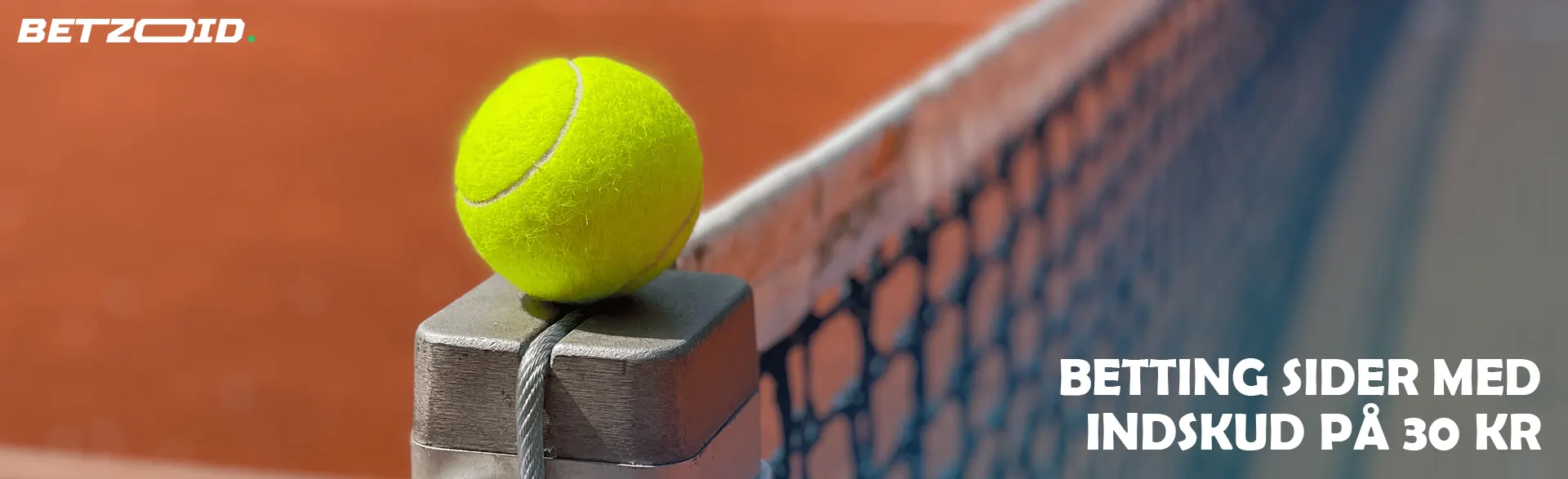 Tennisbolden ligger på kanten af ​​nettet.