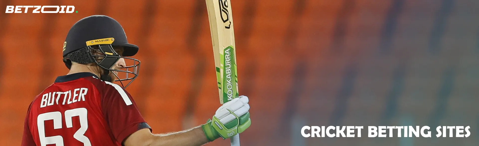 Cricketer with bat against the backdrop of stands.
