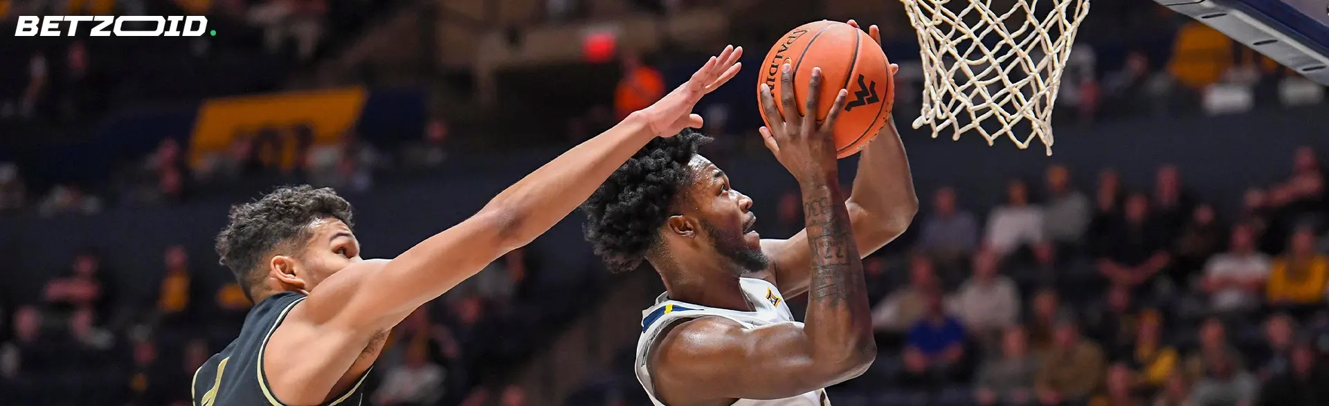 Basketballspillere med bolden i aktion under en kamp.