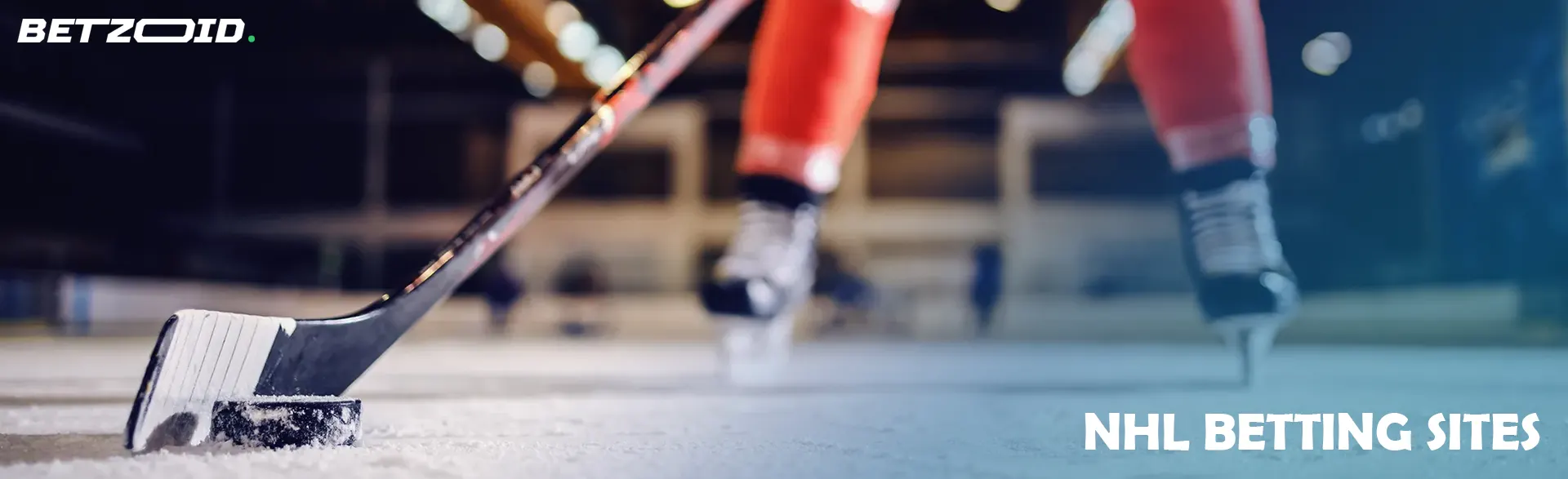 A hockey player holds a stick near the puck.