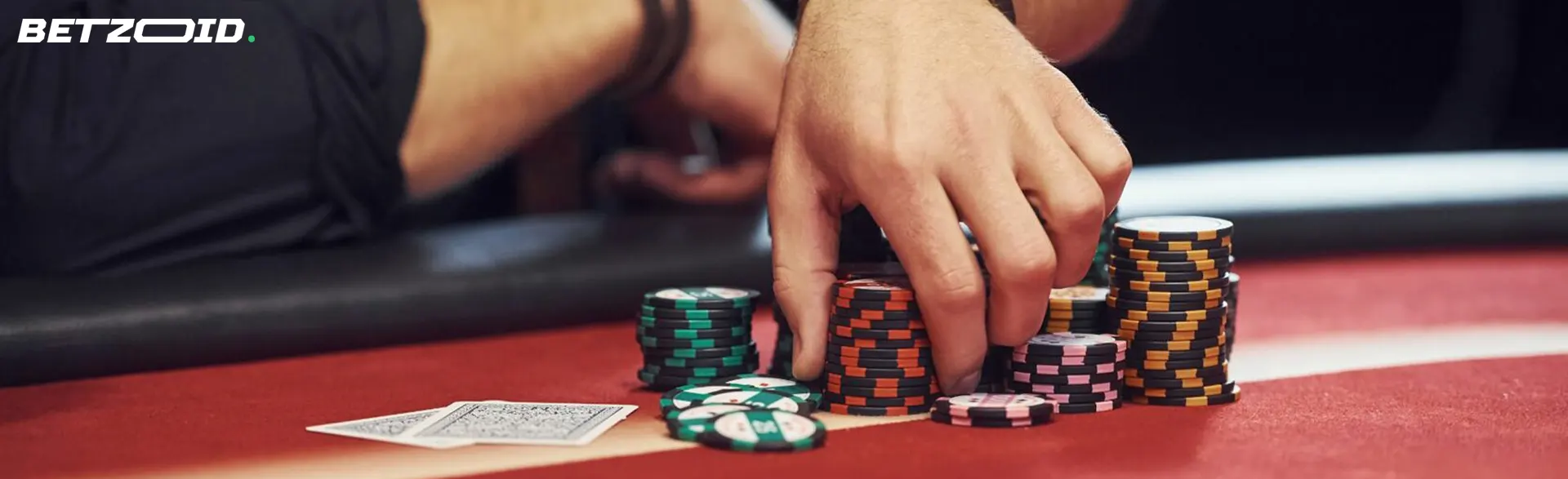 Un joueur tient des jetons sur la table de casino.