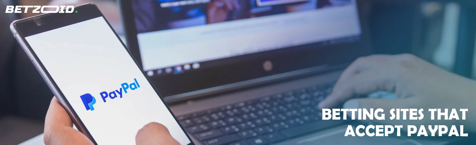 Man holding phone with PayPal logo.