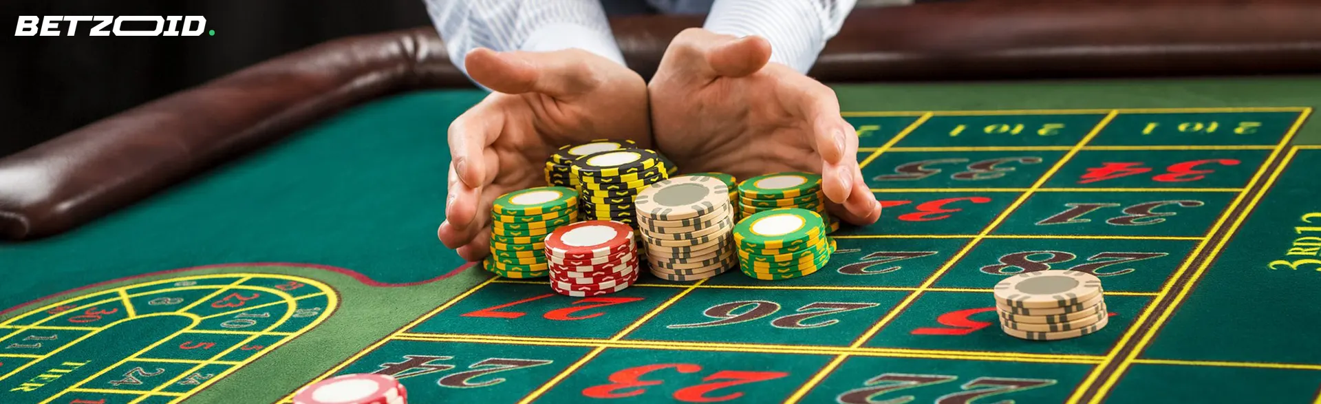 A player holds a pile of chips on a casino table.