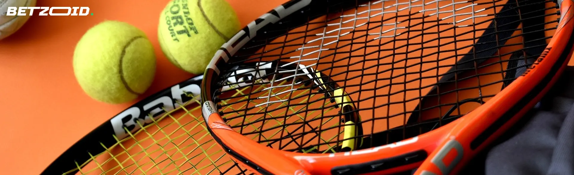 Tennis balls next to rackets.