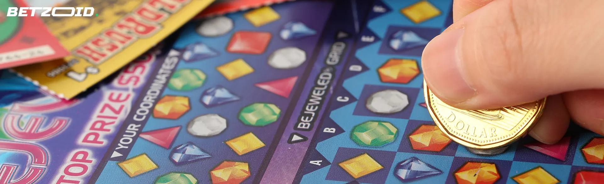 Eine Person löscht Rubbelkarten mit einer Münze.