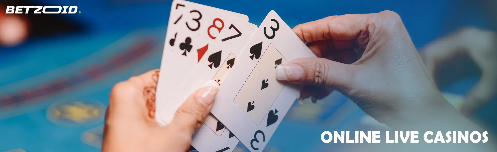 Player holding cards on casino table background.
