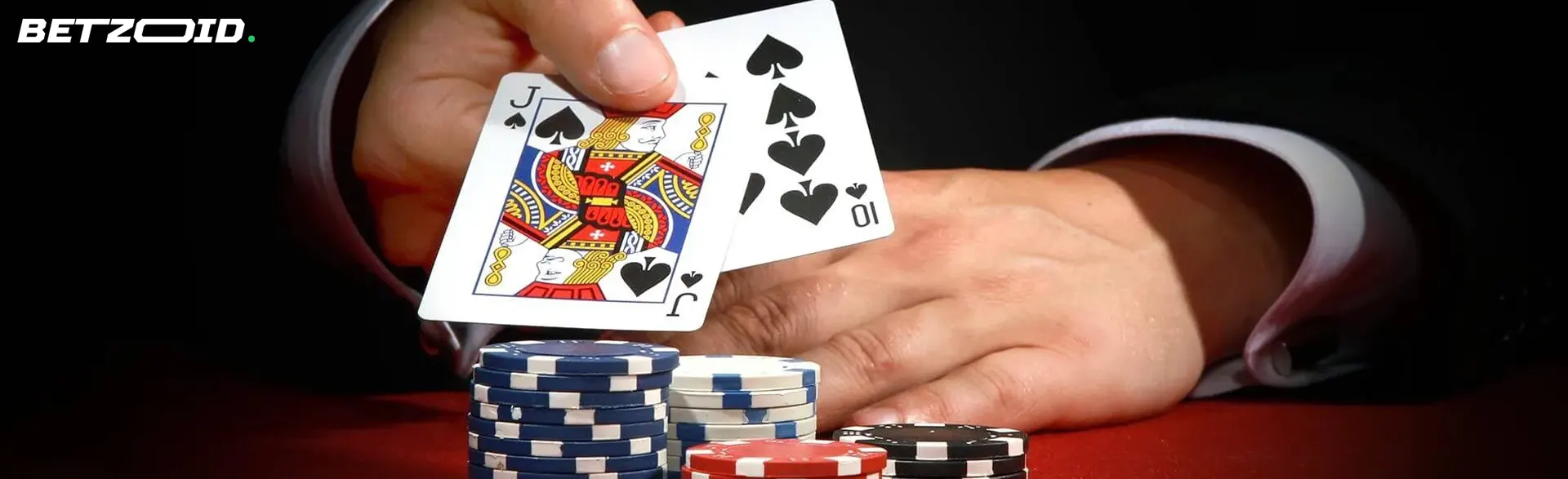 The player holds the cards next to the casino chips.