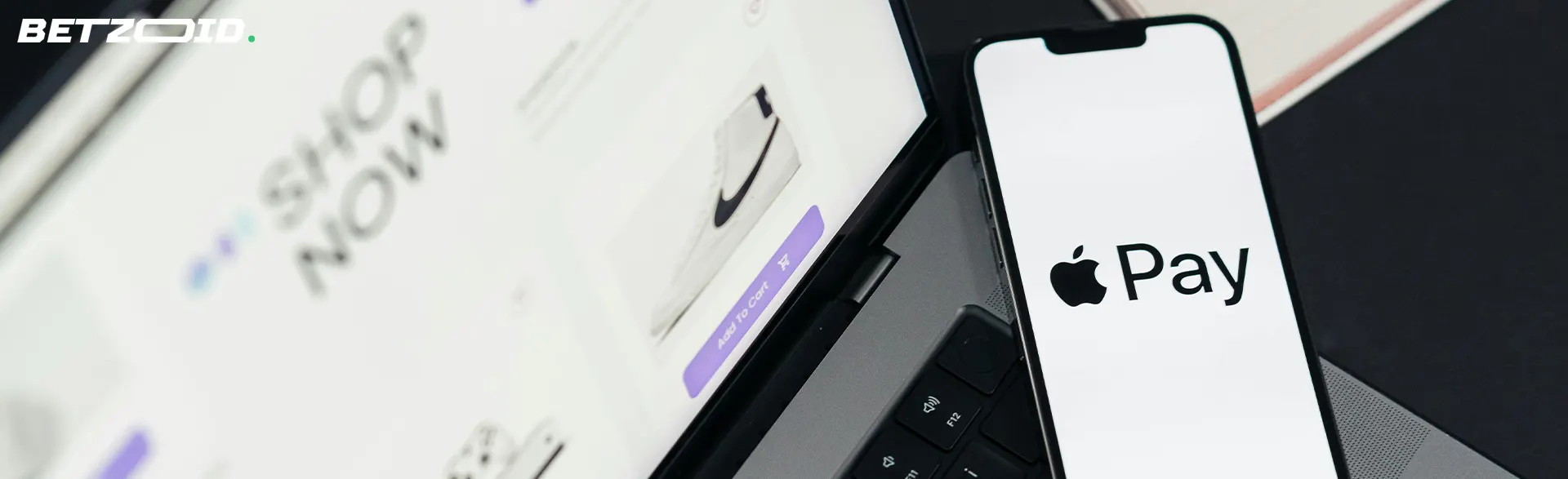 Uno smartphone con Apple Pay accanto a un computer portatile.