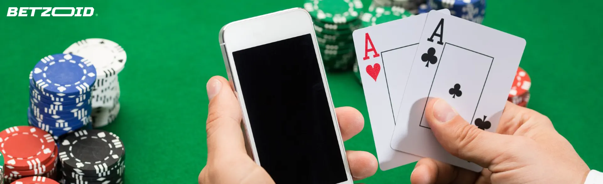 Smartphone and cards in a person's hands on a background of casino chips.