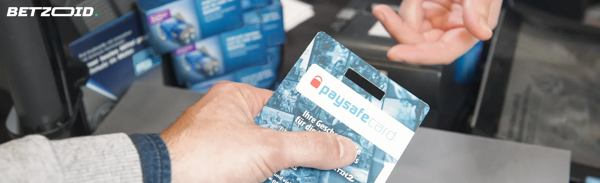 Homme tenant une Paysafecard emballée.