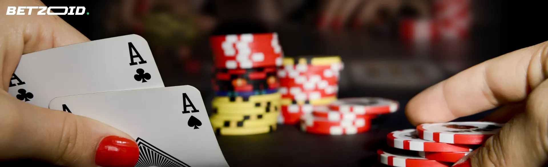 Cards in a player's hand on a background of casino chips.