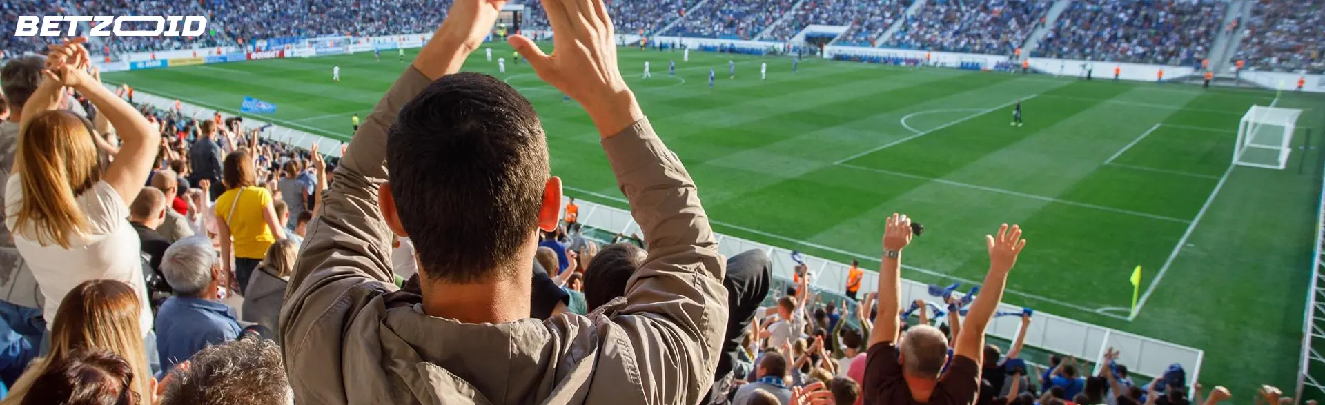 Oamenii stau în tribunele de fotbal.