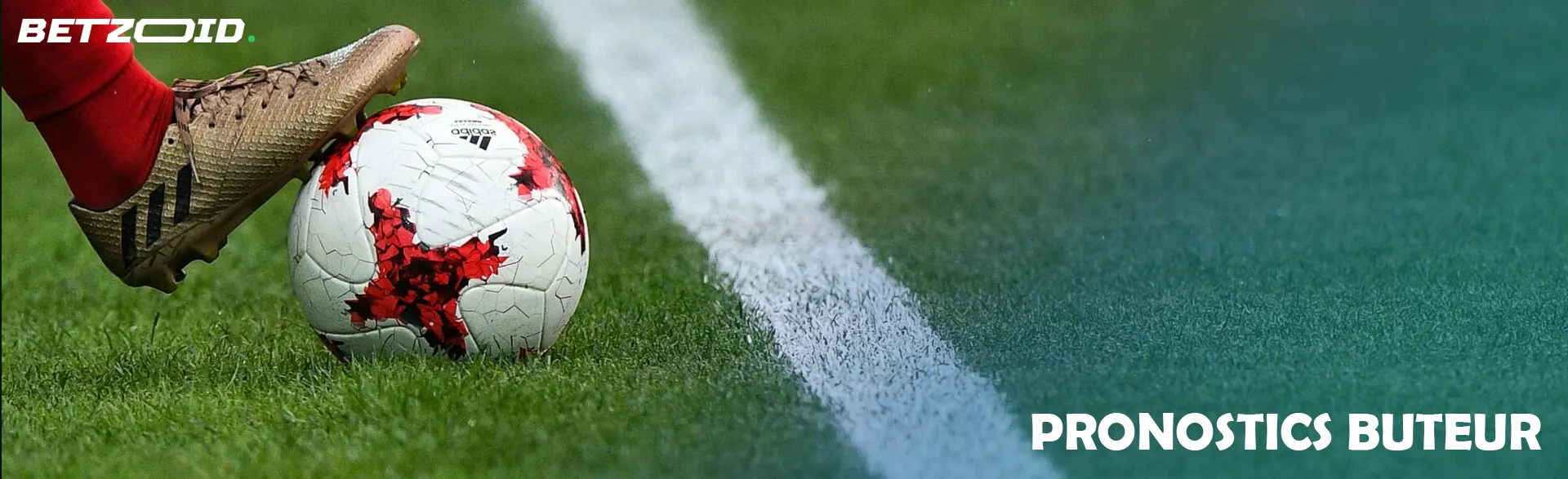 La jambe du footballeur tient le ballon.