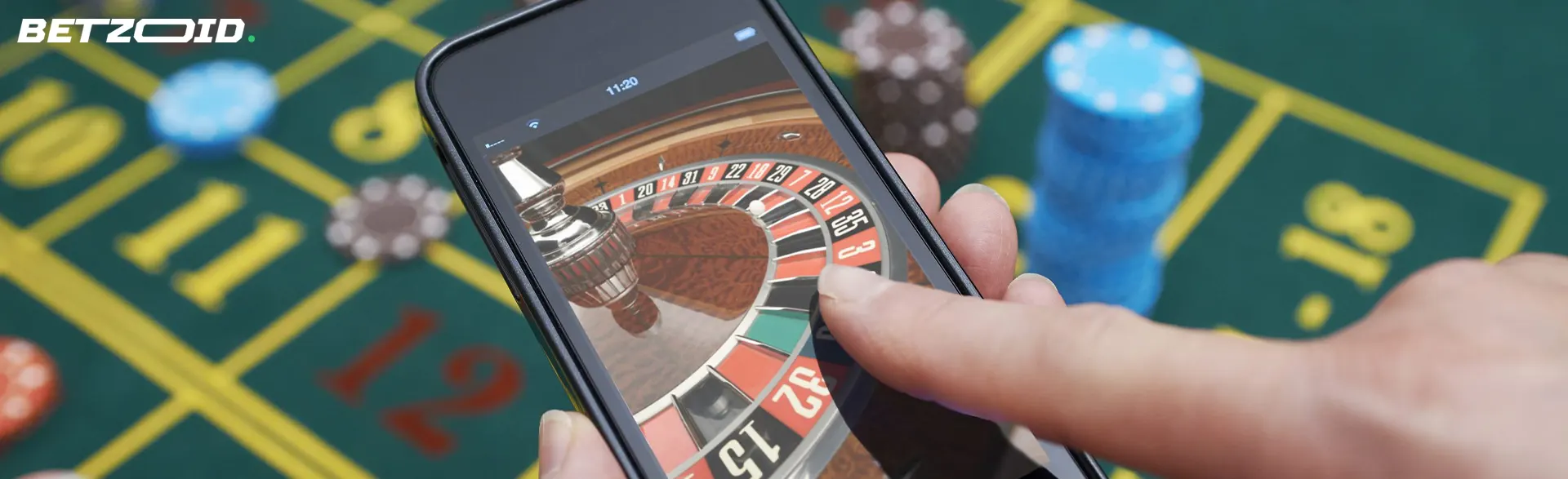 Smartphone met een roulettewiel tegen de achtergrond van een casinotafel.