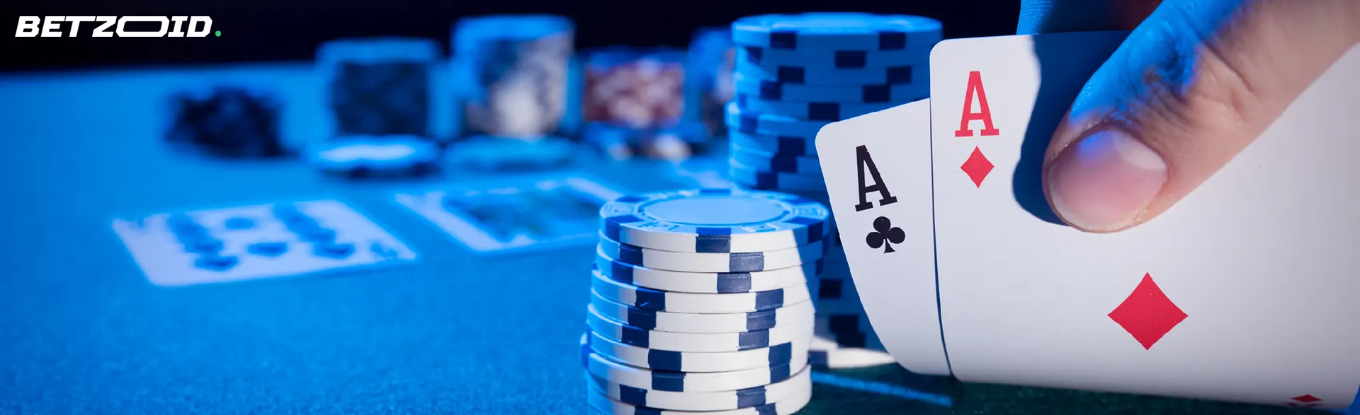 Cards in a player's hand against the backdrop of a casino table.